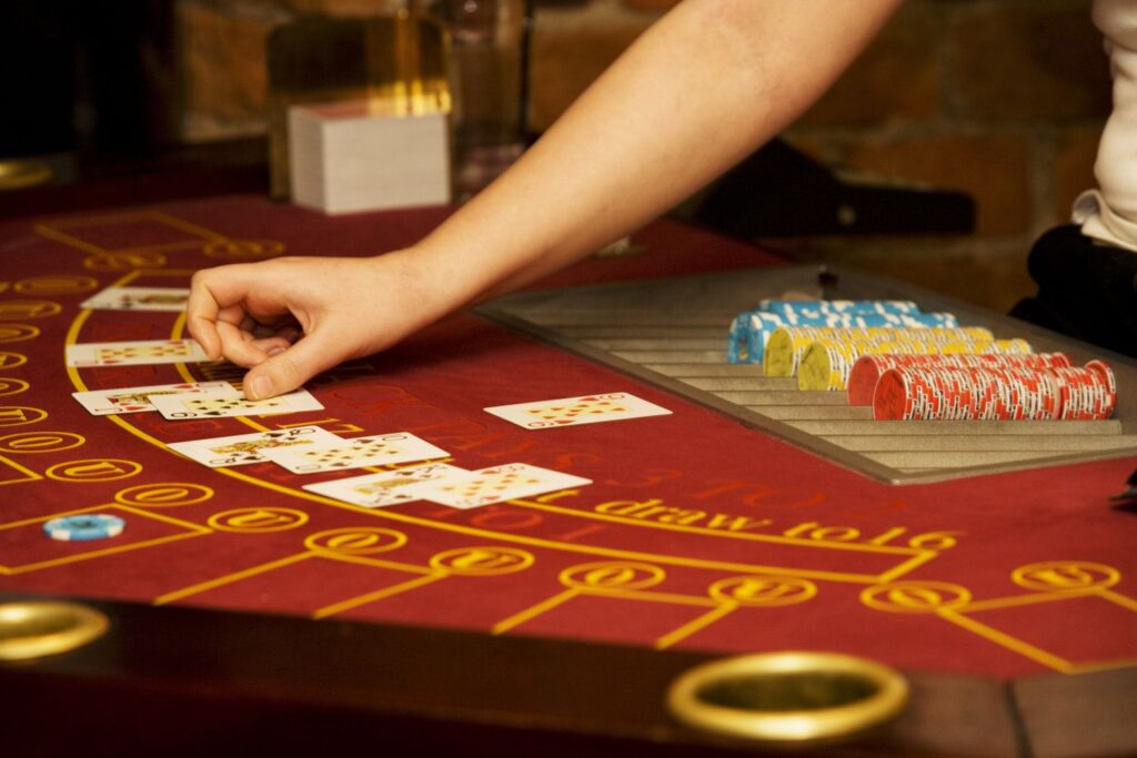 casino worker s hand arranging cards on a poker table in a casino 74425931 5c3a5d8346e0fb0001a7a52b