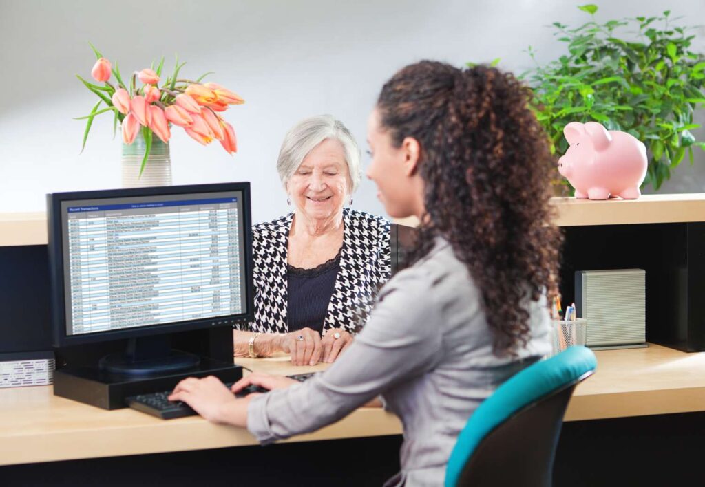 customer in retail banking counter window with bank teller 517491980 5b7c692946e0fb002c4fd78f