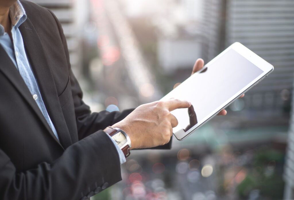 double exposure of professional businessman hold and analyze tablet with cityscape and financial t
