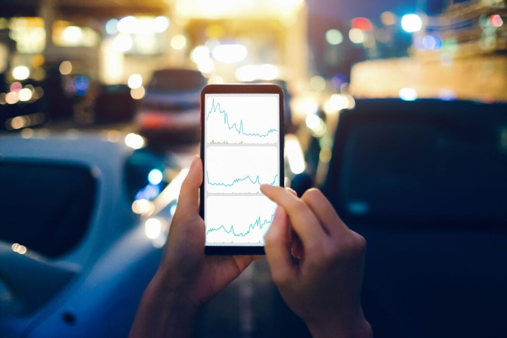 human hands checking financial trading data on mobile phone while walking to car in parking lot 9493