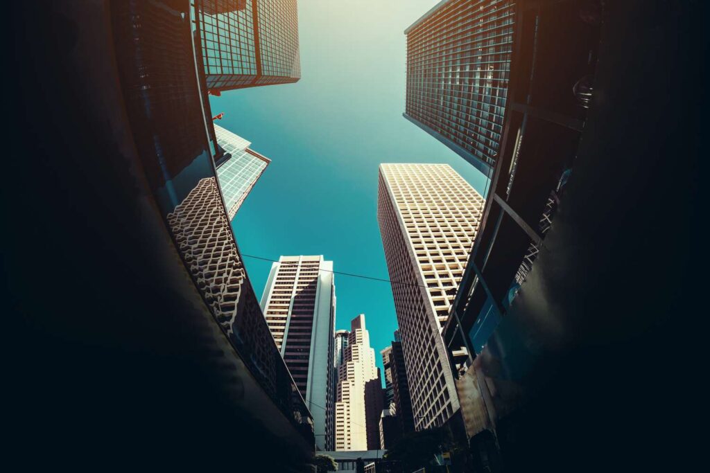 low angle view of contemporary corporate skyscrapers and busy city traffic in financial district of