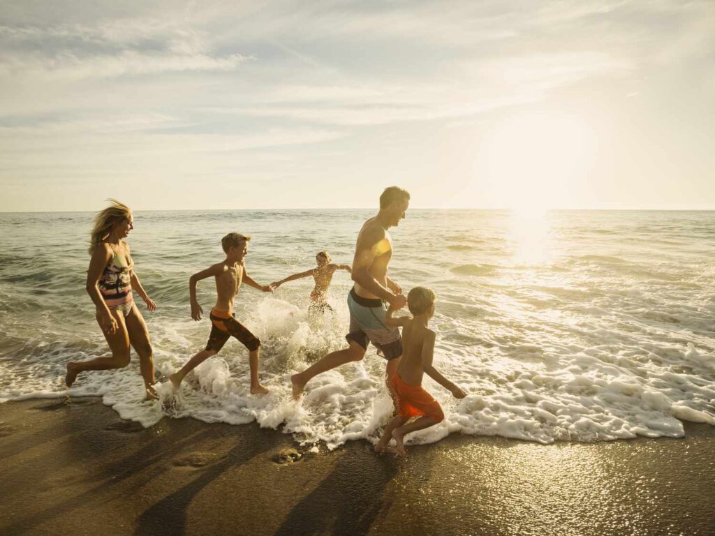 usa california laguna beach family with three children 6 7 10 11 14 15 running on beach 54586