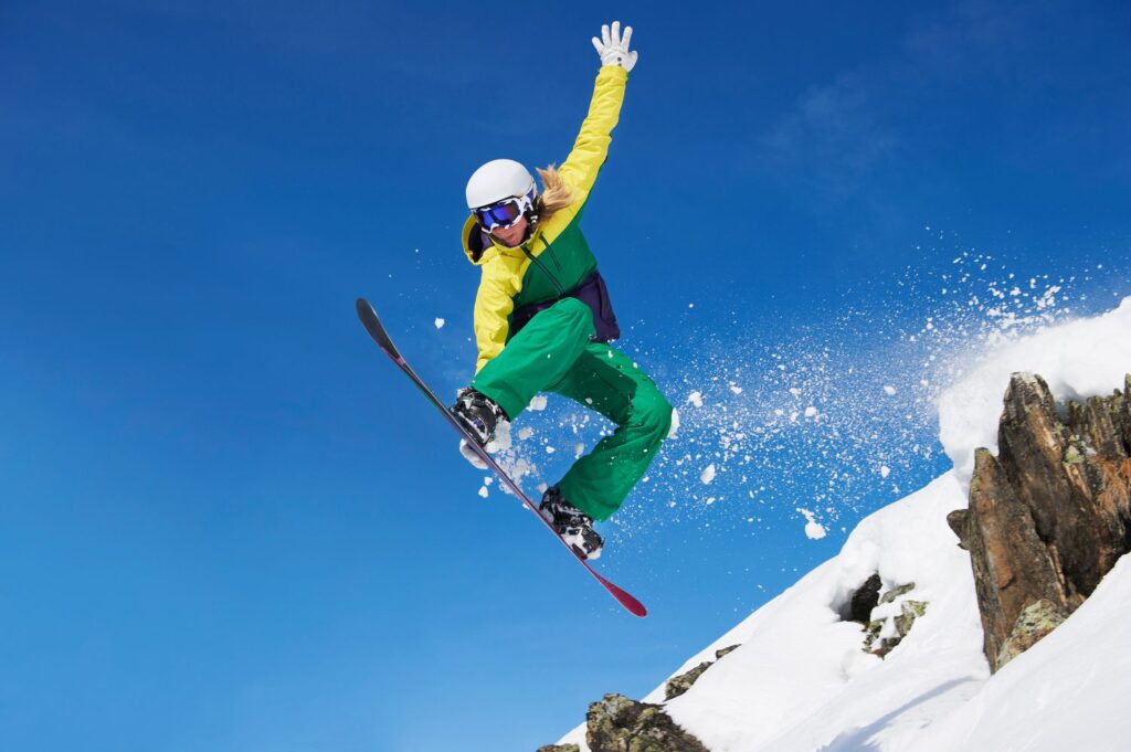young female snowboarder jumping 183742413 829e2f3d83a04ae49c574dc11cf17904
